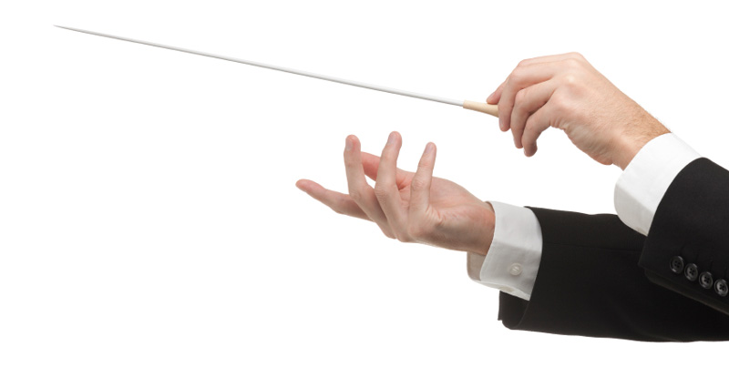 Les mains d'un chef d'orchestre qui conduit ses musiciens